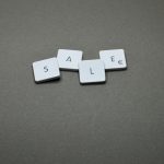 Close-up of tiles spelling 'SALE' showcasing a minimalist design theme.